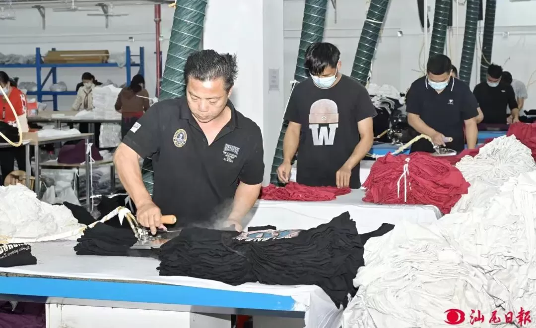 陆河县一服装厂内，工人正在烫衣服。